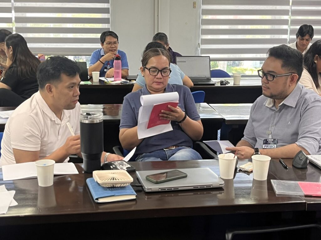 Three managers reviewing printed materials and discussing during the session